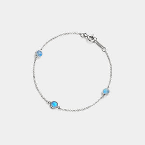 Silver bracelet with three blue gemstones on a light gray background