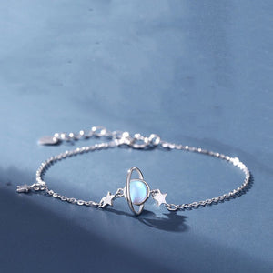 Silver bracelet with a celestial design on a blue background