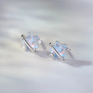 Pair of silver earrings with opal stones on a light gray background