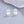 Silver earrings with a star design on a gray surface