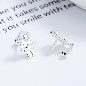 Silver earrings with a star and gemstone design on a white surface.