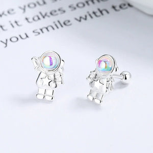 Silver astronaut earrings with rainbow-colored visors on a light background