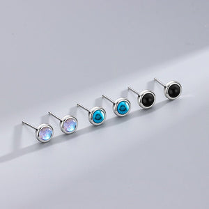 Set of six earrings with multicolored gemstones on a light gray background