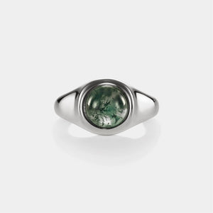 Silver ring with a green stone on a white background