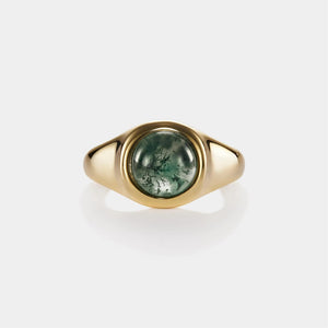 Gold ring with a green stone on a white background