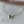 A gold-plated necklace with two butterfly pendants made of mother of pearl, displayed on a marble surface.
