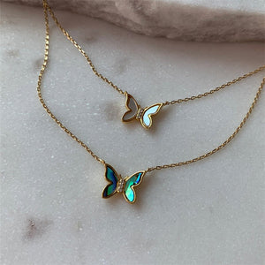 Butterfly-shaped necklaces on a marble surface
