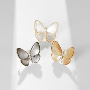 Butterfly-shaped earrings with gold frames on a white background