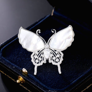 Butterfly-shaped brooch with gemstones on a dark blue velvet background