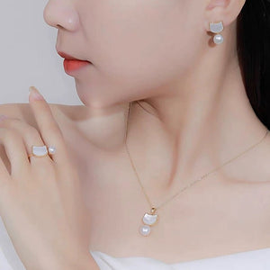 Close-up of a woman wearing pearl earrings and a necklace with a white background