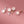 Set of floral earrings with metallic and rose gold finishes on a pink background