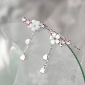 Delicate silver earrings with pink and white stones on a soft gray background