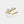 Gold ring with floral design and gemstones on a white background