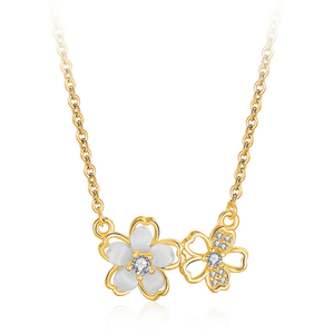 Gold necklace with a white flower and butterfly pendant on a white background