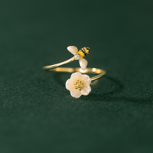 Gold ring with floral designs on a dark green background