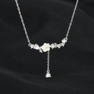 Silver necklace with floral pendants on a black background