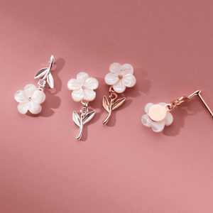 Set of floral earrings on a pink background