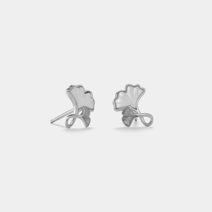 Pair of silver ginkgo leaf earrings on a light gray background