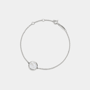 A white gold-plated sterling silver bracelet featuring a small round mother of pearl locket with an adjustable chain.