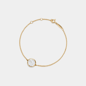 A gold-plated sterling silver bracelet featuring a small round mother of pearl locket with an adjustable chain.