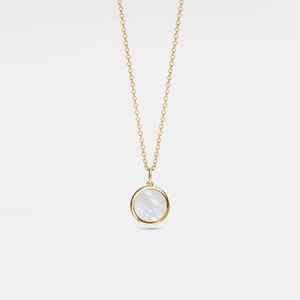 Gold necklace with a round mother of pearl locket on a light gray background