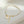 Pearl bracelet with gold starfish and shell charm on a light beige background