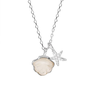 A collection of three mother of pearl seashell starfish necklaces with gold plating, displayed on a beige fabric surface.
