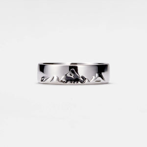 Silver ring with mountain design on a white background