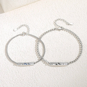 Silver bracelet with a bar clasp on a textured white surface