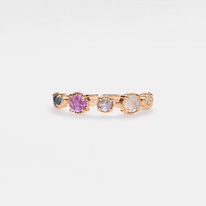 Gold ring with colorful gemstones on a light gray background