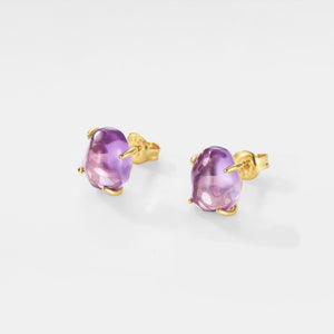 Pair of gold earrings with purple gemstones on a white background