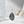 Gold necklace with a teardrop-shaped labradorite pendant on a white surface.