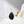 Gold necklace with a black teardrop pendant on a soft white background