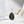 Gold necklace with a green pendant on a white surface