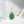 Gold necklace with a green pendant on a white surface