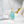 Gold necklace with a light blue pendant on a white surface