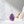 Gold necklace with a purple teardrop pendant on a soft white background