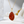 Gold necklace with a red stone pendant on a white surface