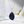 Gold necklace with a blue pendant on a white surface