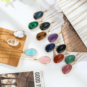 Necklaces with colorful teardrop-shaped gemstones on a white surface.