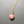 Necklace with a pink bead and gold chain on a gray background