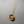Gold necklace with a round amber pendant on a gray background