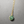Necklace with a green gemstone pendant on a gray background