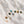 Gold necklaces with various gemstone pendants on a textured white surface