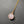 Necklace with a pink pendant and gold chain on a gray background