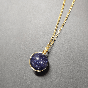 Necklace with a blue pendant on a gray background