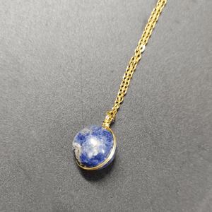 Necklace with a blue pendant on a gray background