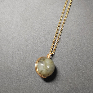 Necklace with a round pendant on a gray background