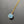 Necklace with a blue pendant and gold chain on a gray background