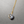 Necklace with a gray marbled pendant on a gold chain against a gray background